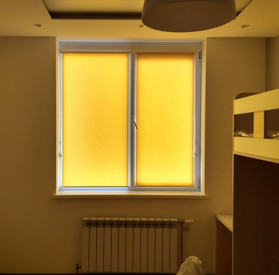две желтые рулонные шторы